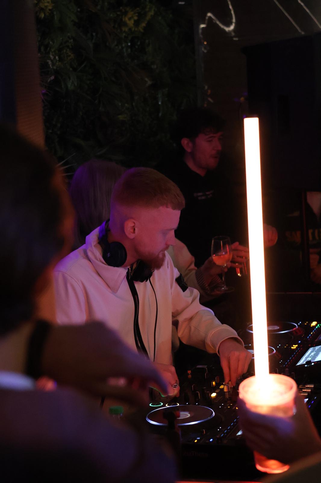 Ben Henderson DJing on CDJs with headphones at a London venue